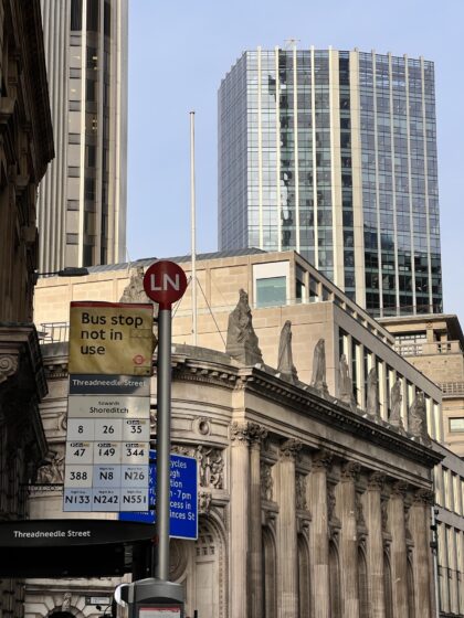 London bus stop sign and background buildings